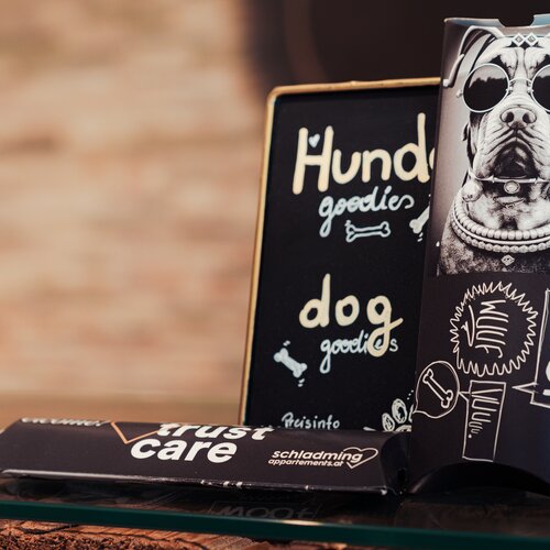 Chalkboard sign reads Hund goodies beside a dog poster | © TIEBER