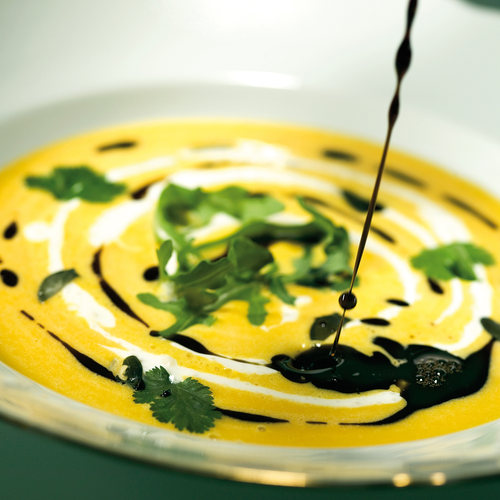 Creamy orange soup with cilantro garnish and balsamic drizzle | © Robert Sommerauer