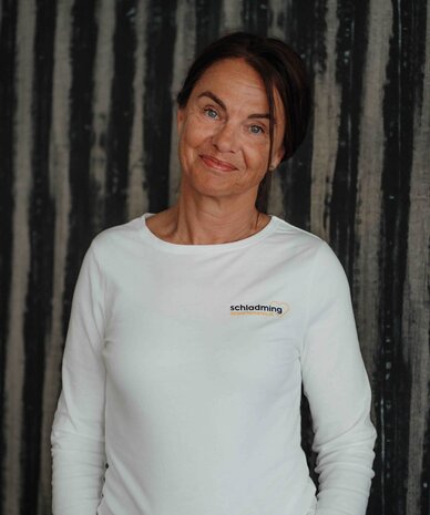 Woman in white long-sleeve shirt with Schladming logo