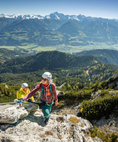 Two hikers ascend a rocky mountain with a safety cable. | © Marion Omulec | Schladming-Dachstein