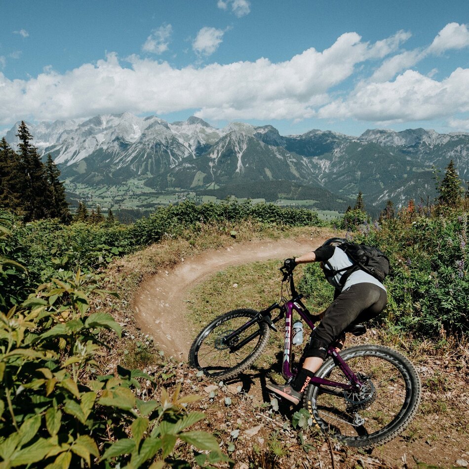 Mountain biker leaning into a turn on dirt trail