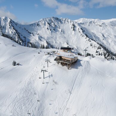 Snowy alpine ski area with chairlift and lodge. | © ERWIN PETZ