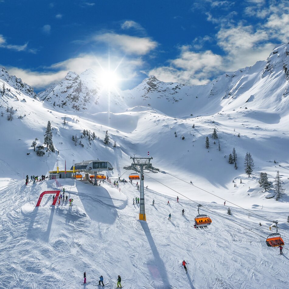 Snowy alpine slopes with skiers and a ski lift