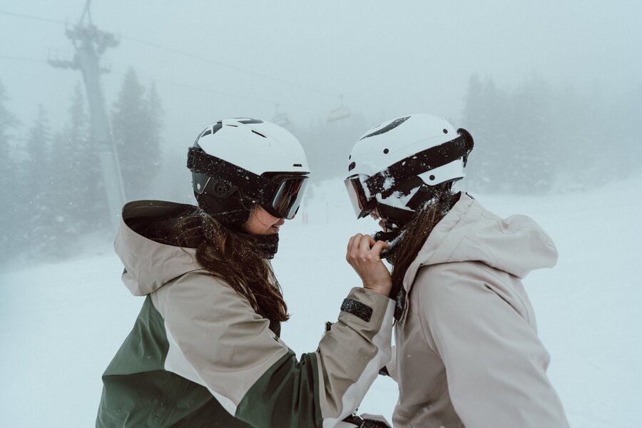 Two people in ski gear face each other in snow