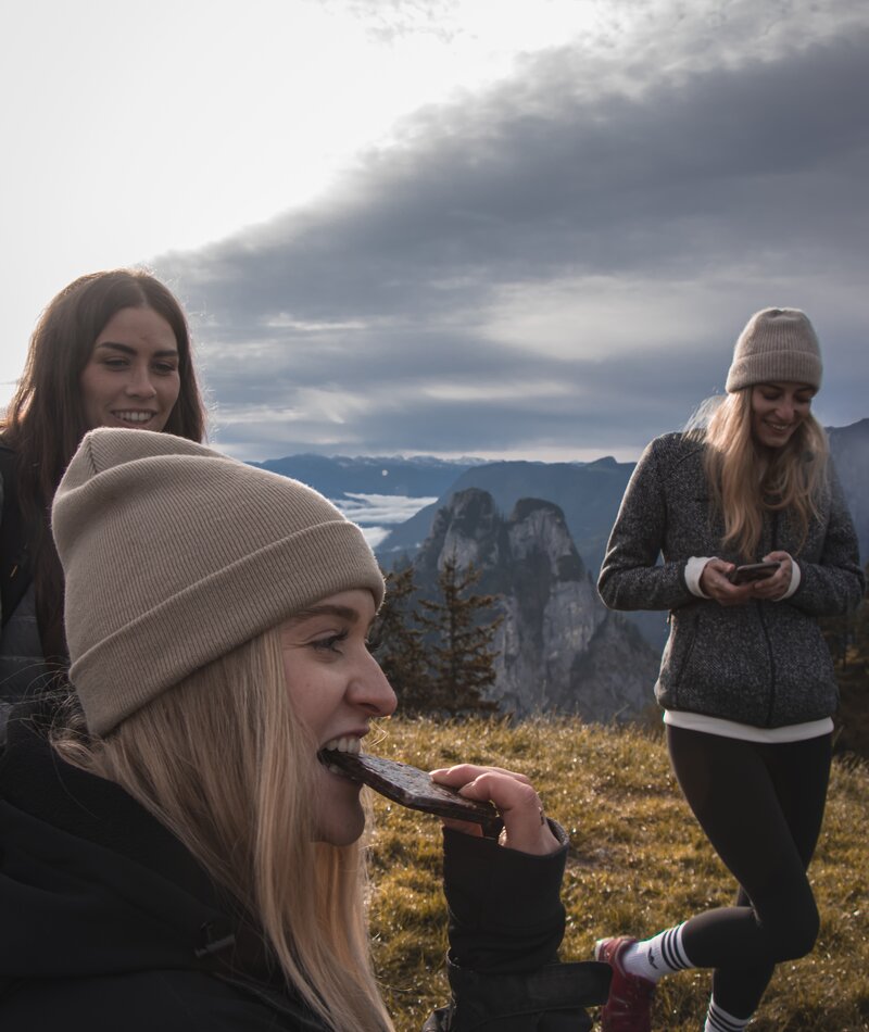 Group of young people wearing beanies outdoors with mountains