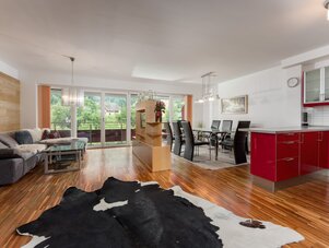 Offener Wohn- und Essbereich mit roter Küche