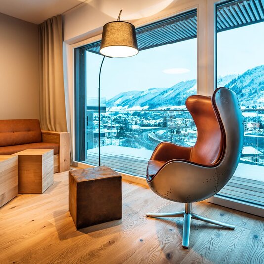 Modern living room with leather chair and snowy mountain view