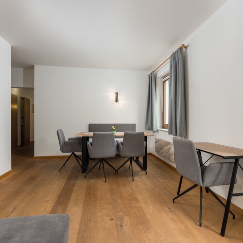 Bright dining area with wooden floor and grey chairs