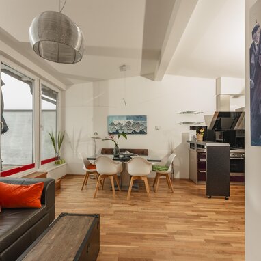 Open-plan living area with sofa, dining table, and large windows