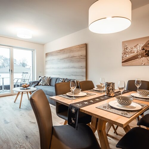 Open-plan living and dining area with a snowy balcony view