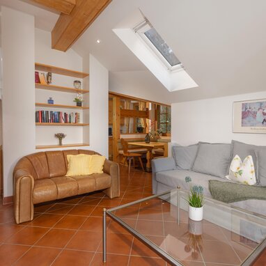 Bright living room with skylight, brown leather sofa and gray sofa
