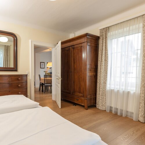 Bedroom with large wooden wardrobe, matching dresser and mirror