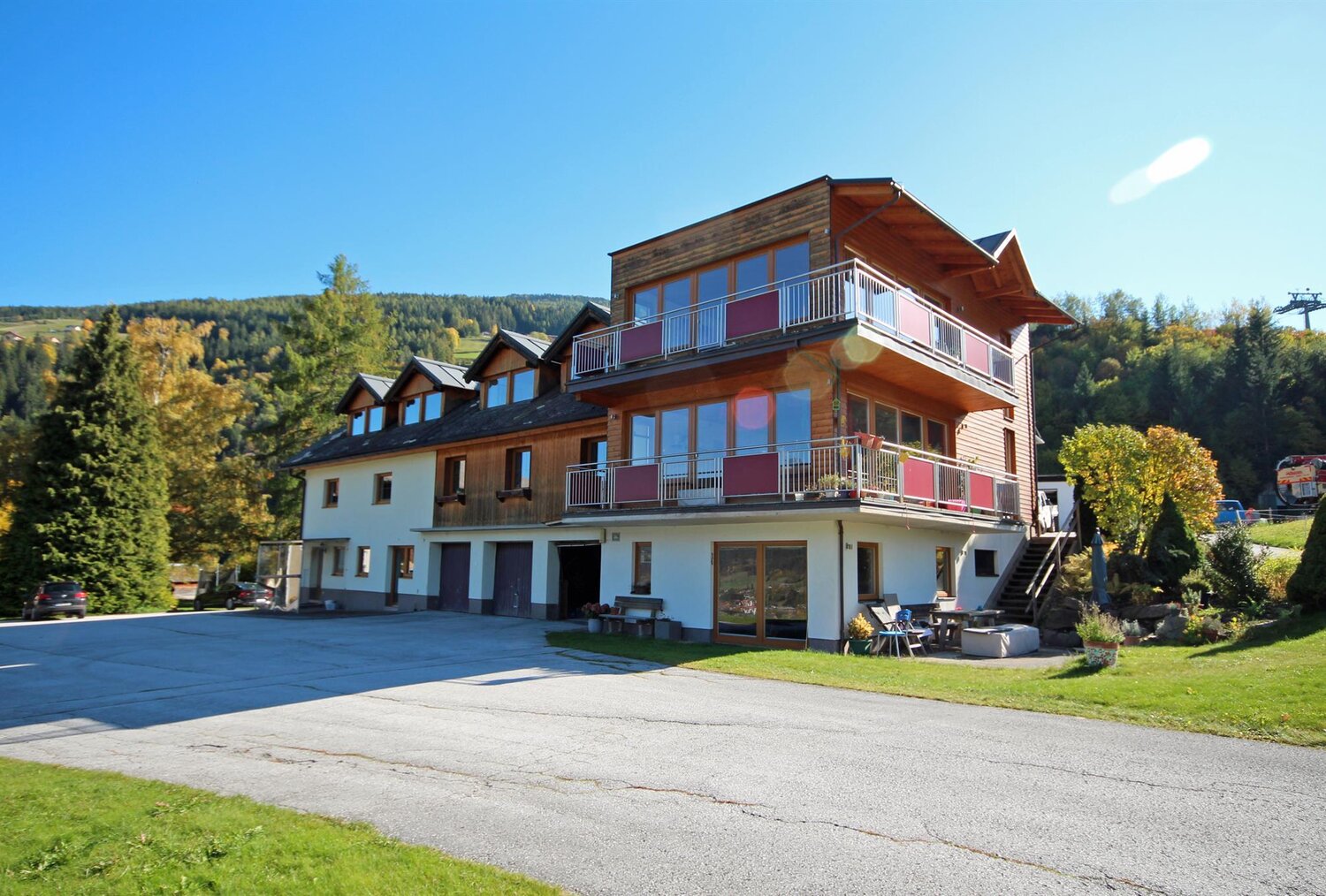 Multi-story wooden lodge with balconies by a hillside