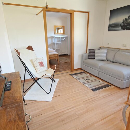 Bright living room with gray sofa, TV, and chair