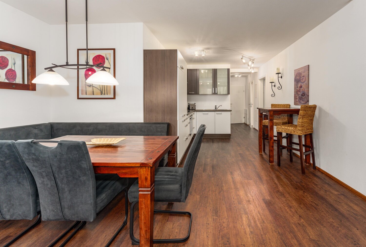 Open-plan dining area with wooden table and gray chairs