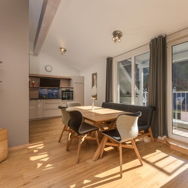 Bright open-plan dining area with wooden floor and glass doors