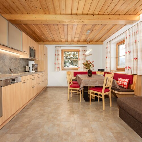 Cozy modern kitchen and dining area with wooden ceiling