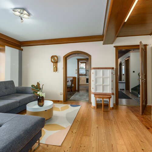 Wohnzimmer mit grauer L-Form-Sofa und Holzboden