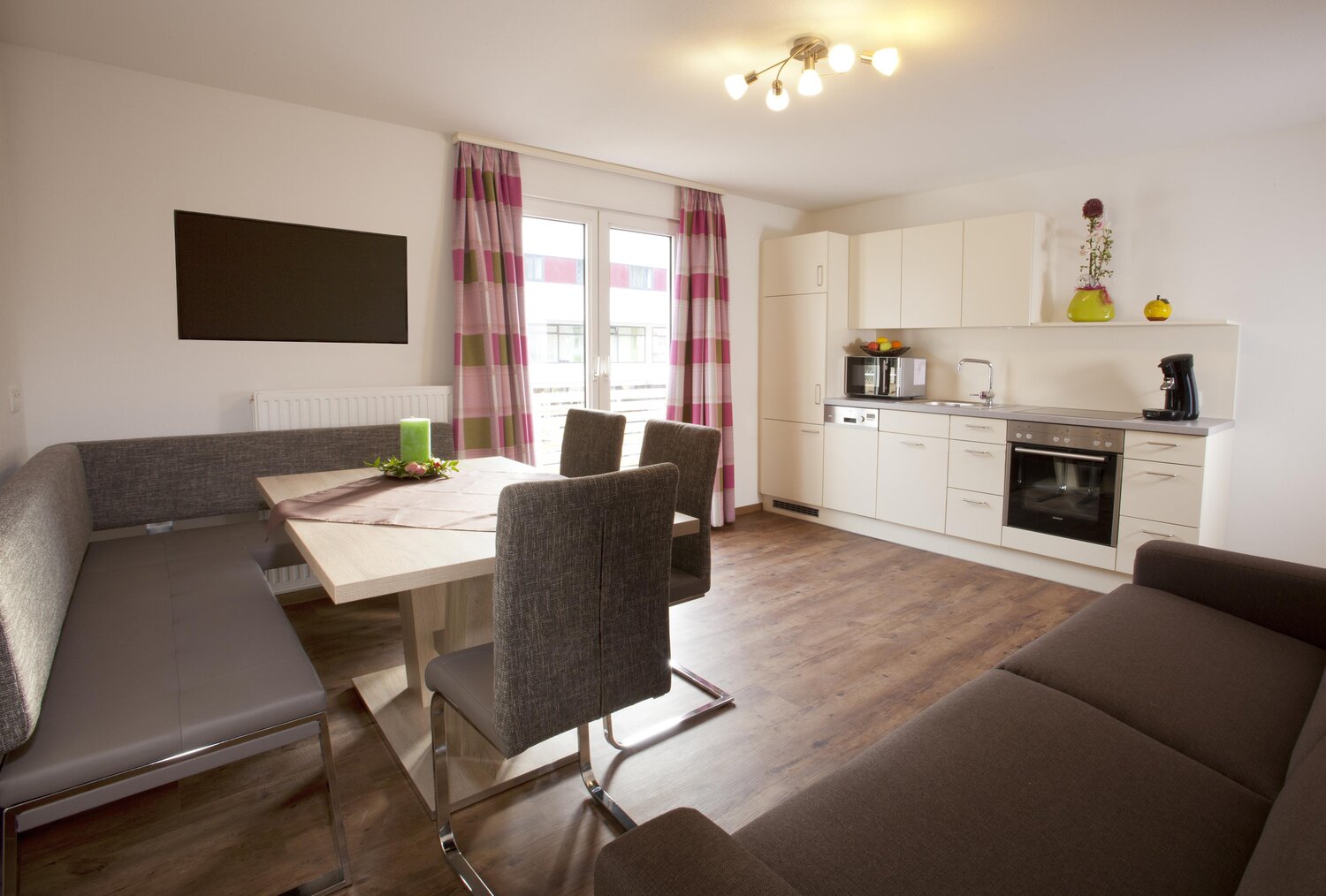 Offener Wohnbereich mit Esstisch, Stühlen und moderner Küche