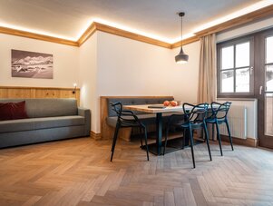Living area with sofa, dining table and large window