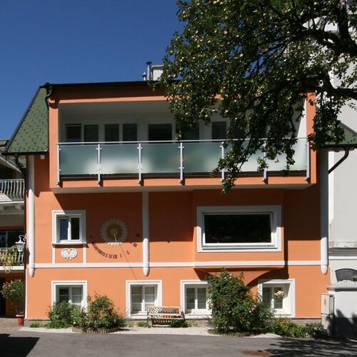 Orange building with balcony and garden in courtyard