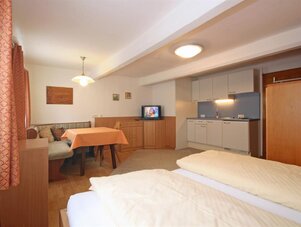 Bedroom suite with kitchenette, two beds, and sofa.