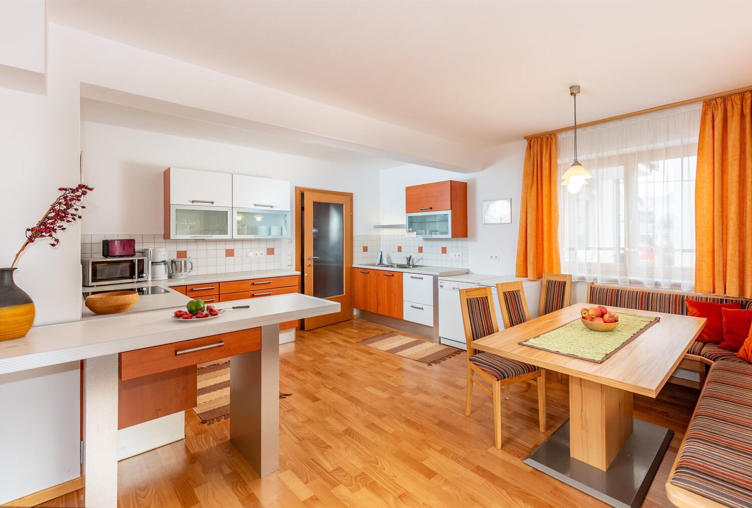 Bright modern kitchen with wooden cabinets and dining table.