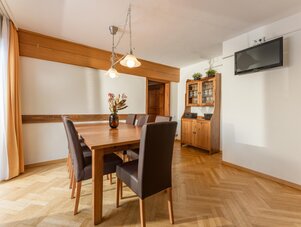 Holztisch im Esszimmer, braune gepolsterte Stühle, heller Raum