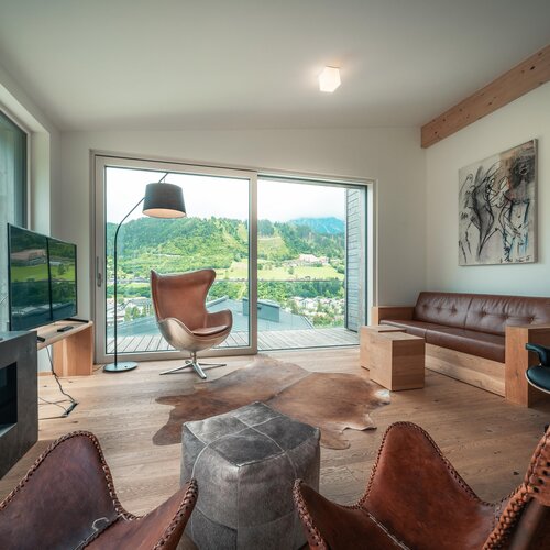 Modern living room with leather seating and panoramic hillside view