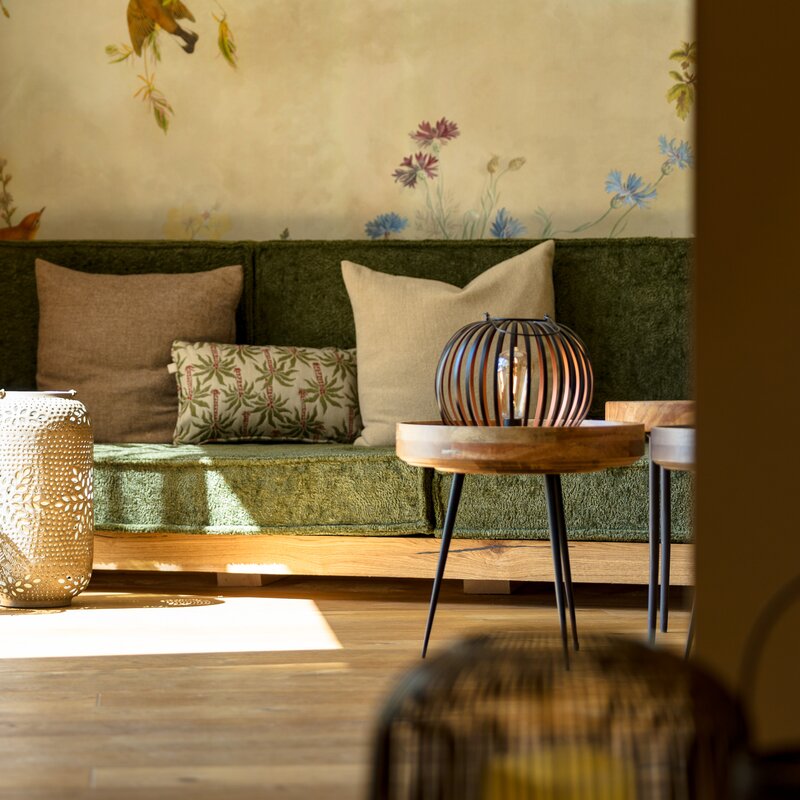 Cozy living room with green sofa and decorative lanterns.