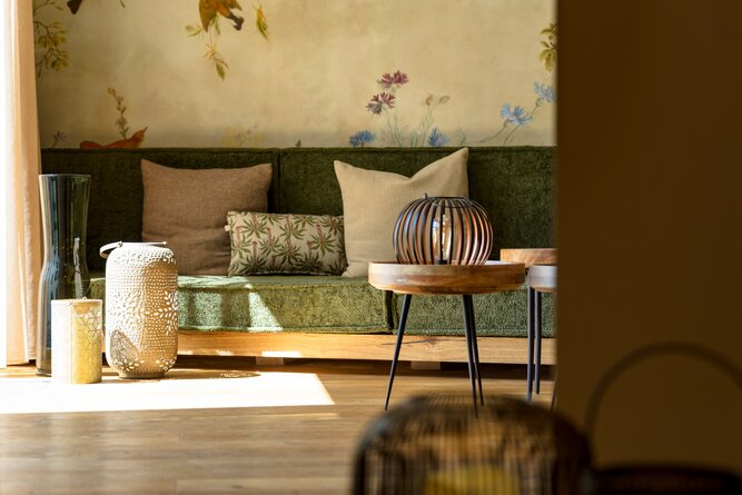 Cozy living room with green sofa and decorative lanterns.