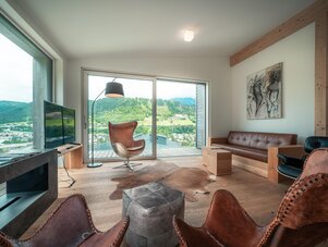 Bright modern living room with large glass doors and mountain view.