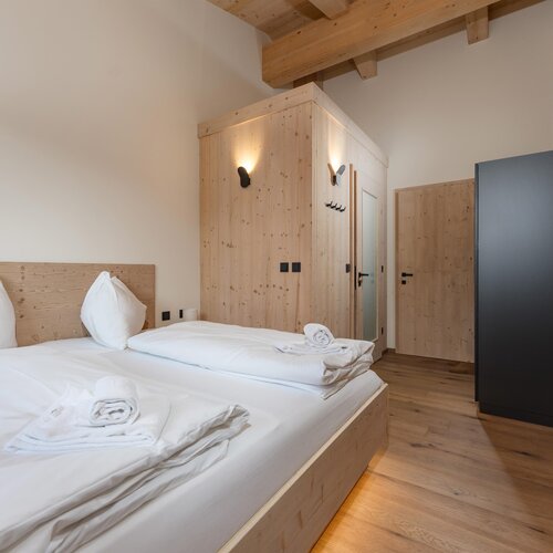 Modern wooden bedroom with large bed and wardrobe