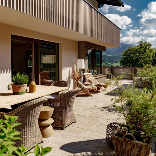 Terrace with wooden table, wicker chairs, and potted plants
