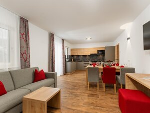 Offener Wohnbereich mit grauer Couch und Esstisch.