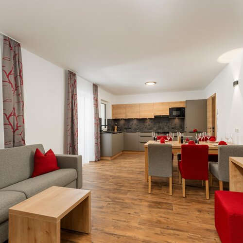 Offener Wohnbereich mit grauer Couch und Esstisch.