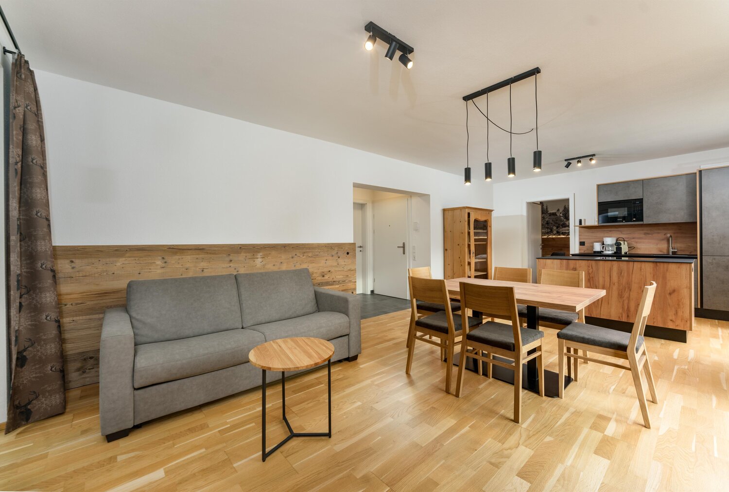 Open-plan living and dining area with wooden furniture.
