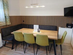 Holztisch mit grünen Stühlen im Konferenzraum