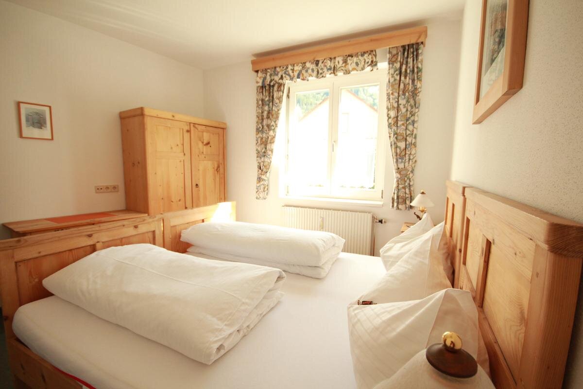 Cozy wooden bedroom with two beds and wardrobe