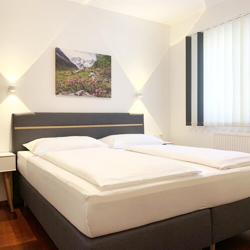 Modern hotel bedroom with large bed and artwork