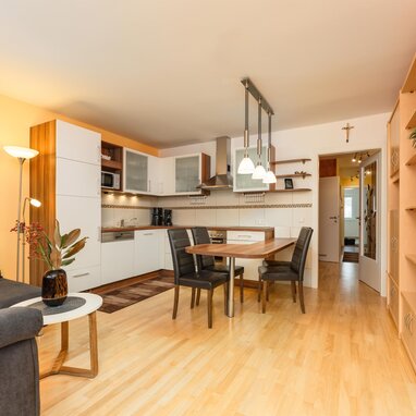 Open-concept living area with sofa, kitchen, and dining table.