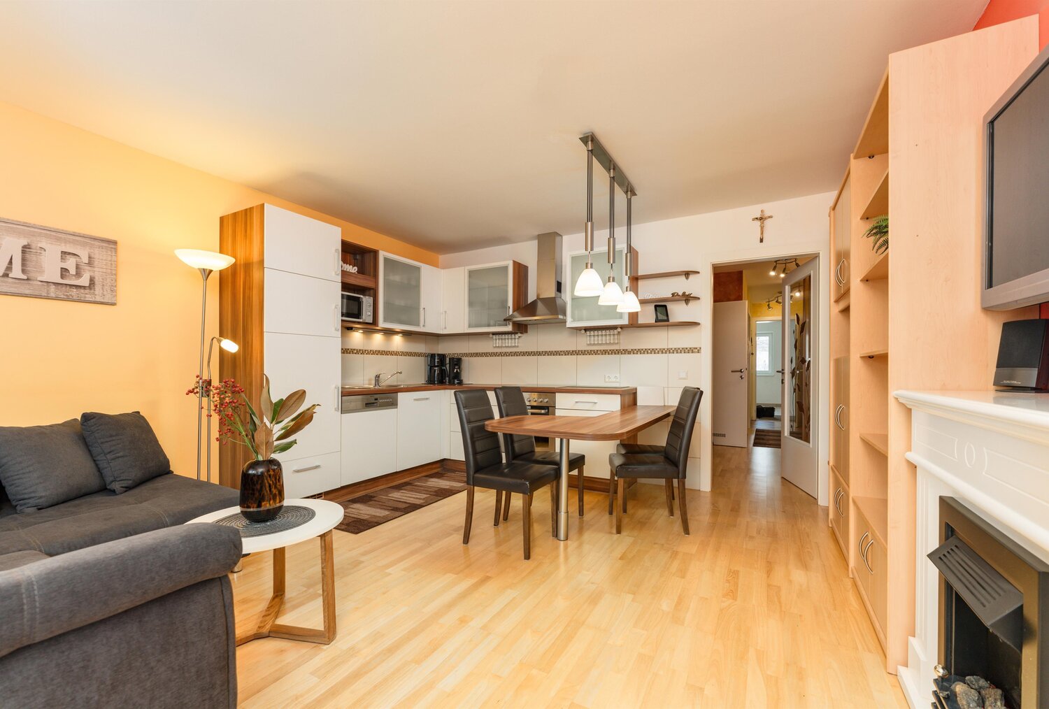 Open-concept living area with sofa, kitchen, and dining table.