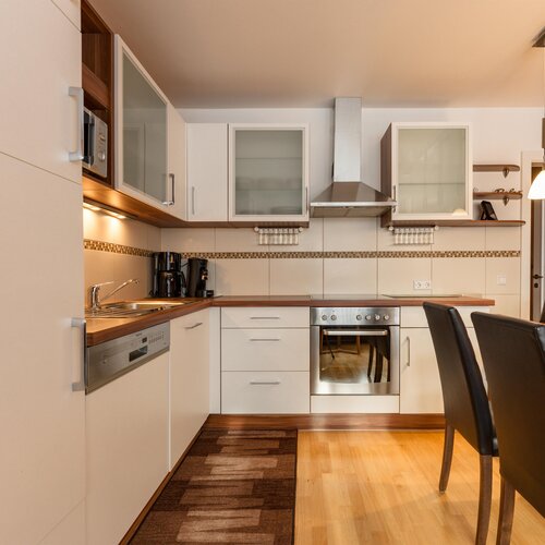 Modern white kitchen with wooden countertops and dining table