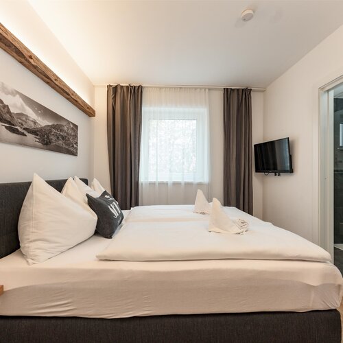 Modern hotel bedroom with large bed and en-suite bathroom