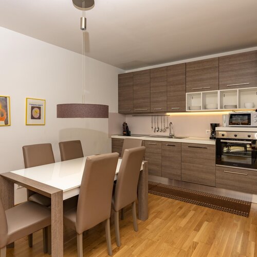 Kitchen with wooden cabinets, dining table and beige chairs
