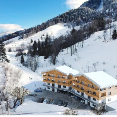 Schneebedeckte Berghütte mit holzverkleideten Chalets