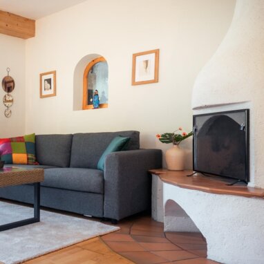 Living room with gray sofa, armchairs, and fireplace. | © TIEBER