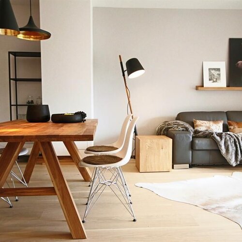 Bright open-plan living and dining area with wooden table and sofa