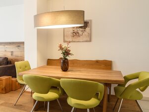 Wooden dining table with lime green chairs in a bright room