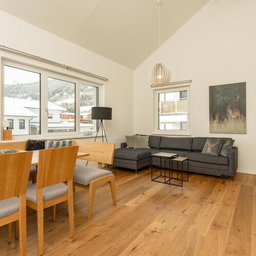 Helles offenes Wohnzimmer und Esszimmer mit Holzmöbeln und Bergblick